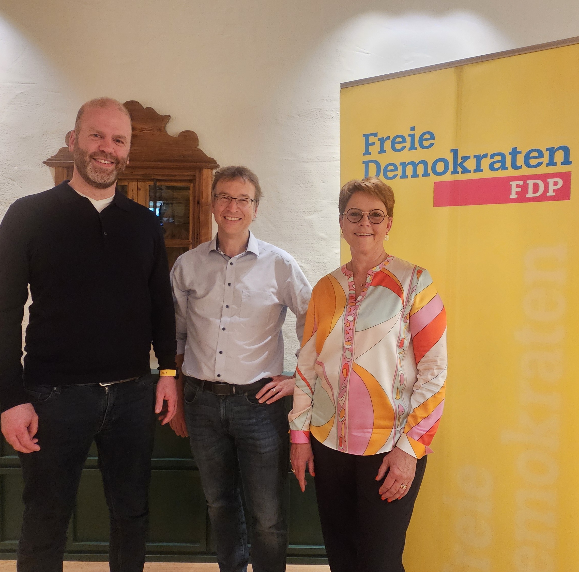 Foto von FDP Bayern Generalsekretär Daniel Kuhagen, Michael Lehmann-Horn, wiedergewählter Ortsvorsitzender der FDP Grünwald-Straßlach und Monika Bock, Kreisvorsitzende der FDP München-Land.